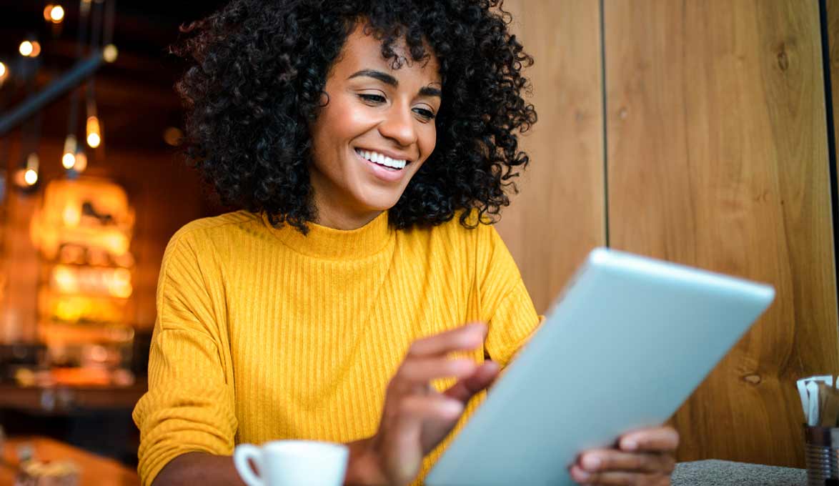 Woman at coffee shop on a tablet.